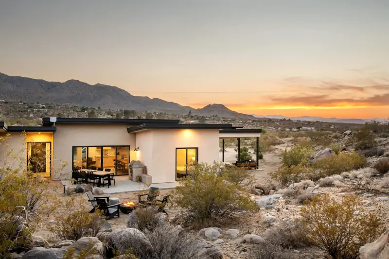 Backyard: The house backyard features a dining table for 6, a fire pit, a gas grill and boulders. A covered lounge seating sectional next to the house.