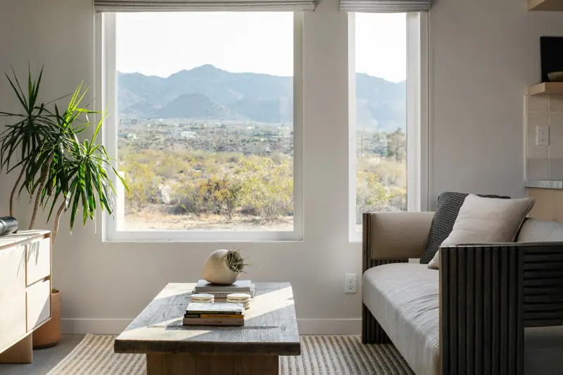 Living room: Mountain views from the living room. The living room features designer furniture pieces and a 65" 4K Sony Smart TV with a Sonos sound bar.